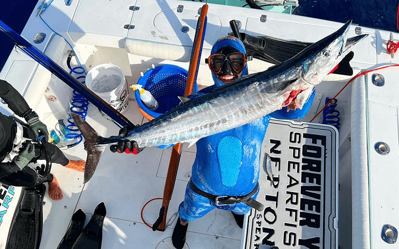 Diver on a Forever Young spearfishing charter boat holding a large wahoo in Islamorada, Florida.