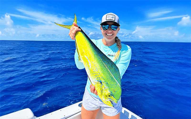 Angler holding a bright mahi-mahi during an offshore fishing trip in Islamorada, Florida Keys.
