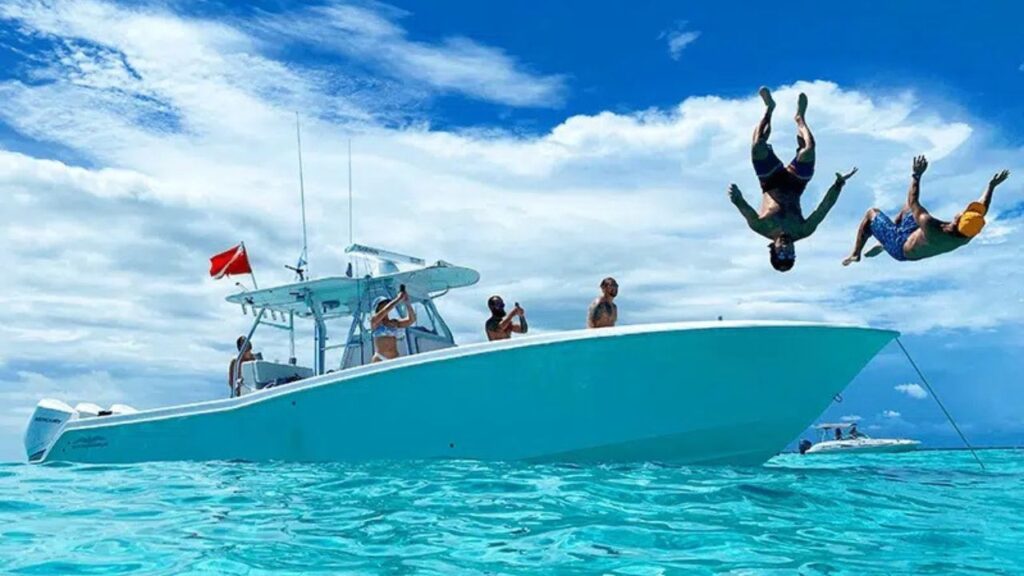 Guests jumping from a boat into clear water during an Islamorada Sandbar trip.