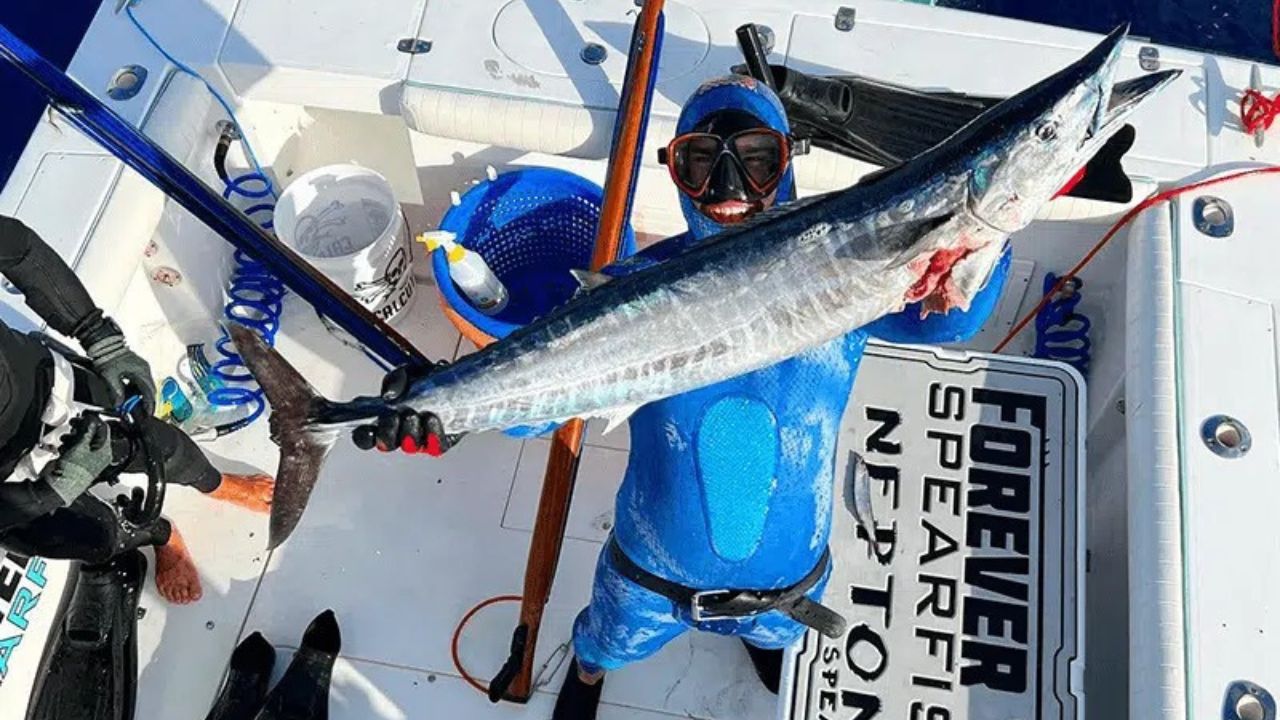 Spearfishing diver holding a large wahoo aboard a Florida Keys charter boat.